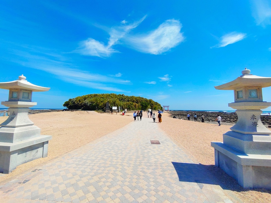 青空の下、白砂の参道が真っ直ぐに伸び青島へ続く青島神社の入口の景色