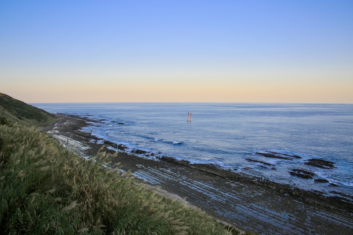 วิวชายฝั่งนิชินันยามเย็น พร้อมทะเลที่สงบและชั้นหินโอนิโนะเซ็นตะคุอิตะ