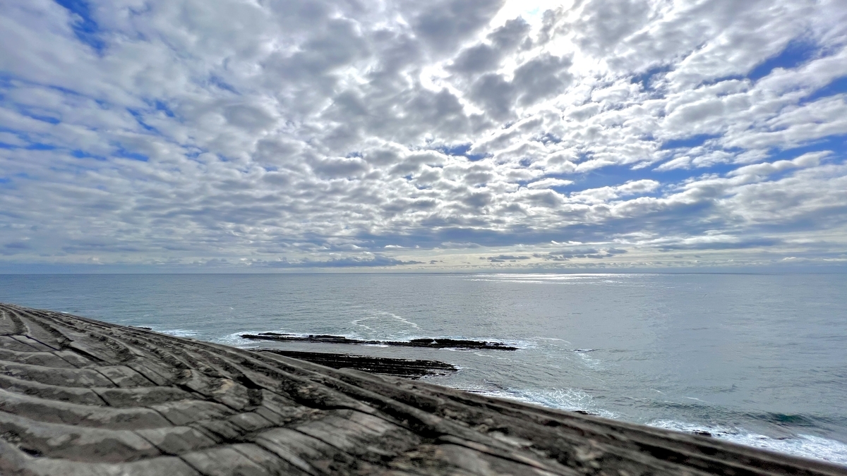 雲が広がる空と太平洋を望む鬼の洗濯板の風景