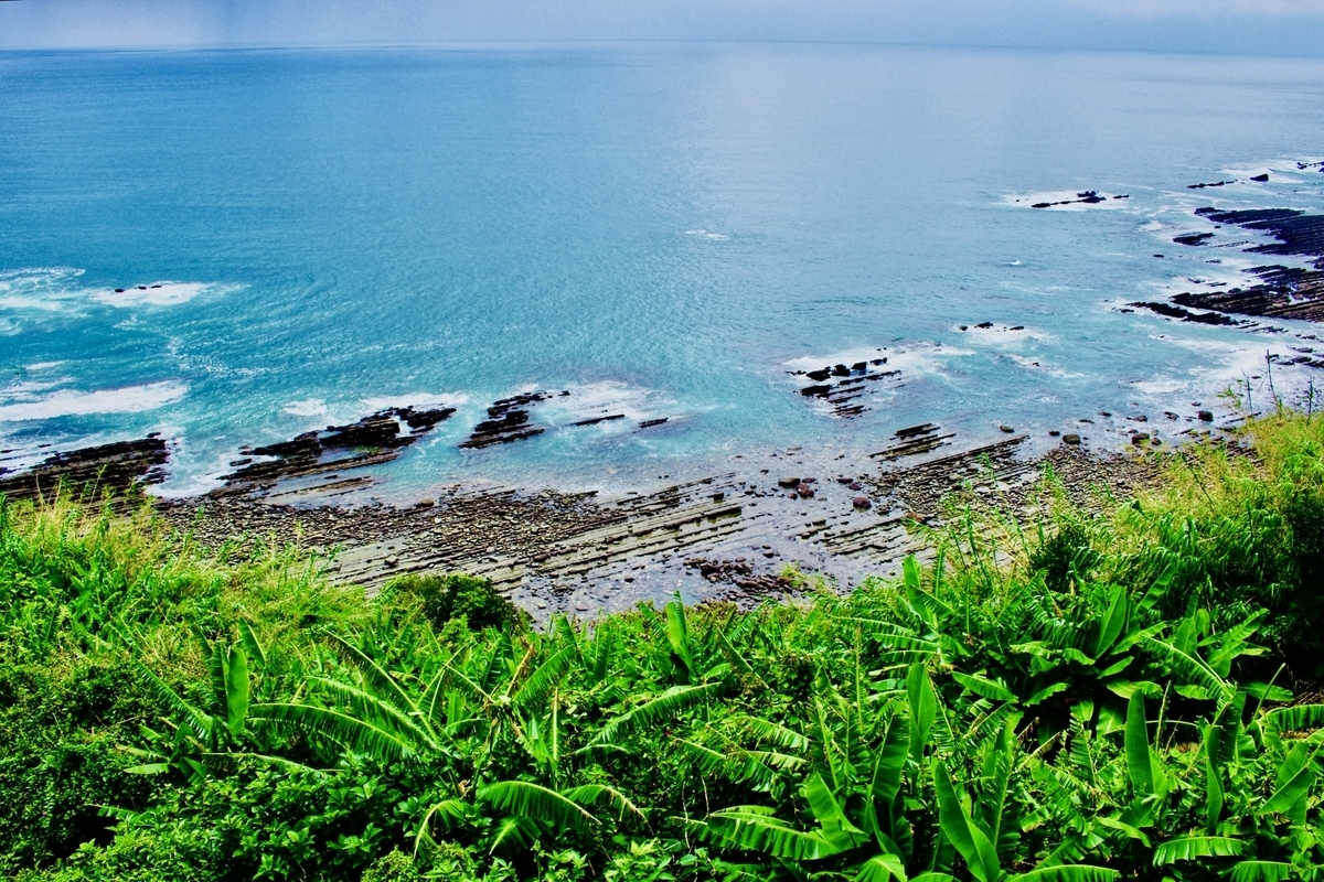 濃い青色の海と岩礁が広がる日南海岸の景色
