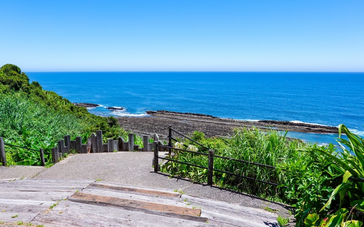 鬼の洗濯板へ続く緑に囲まれた階段と海の景色