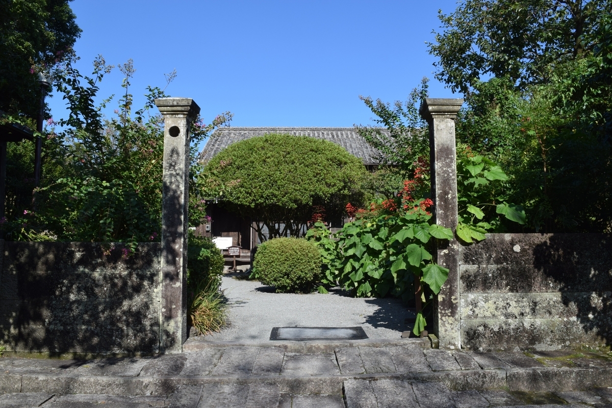 돌담과 정원수로 둘러싸인 고무라 주타로 기념관의 입구 경관