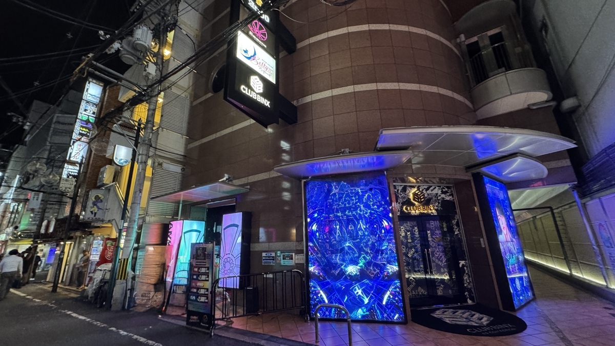 Exterior de Ammona con iluminación azul alrededor de la entrada por la noche