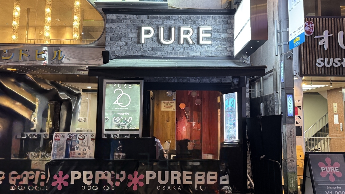 Fachada y entrada de PURE osaka iluminadas por la noche