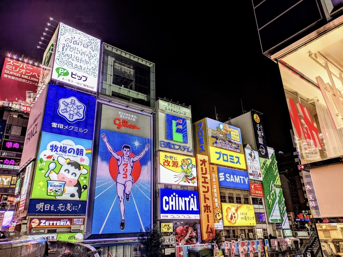 Vista nocturna de la concurrida calle frente al cartel de Glico en Dotonbori