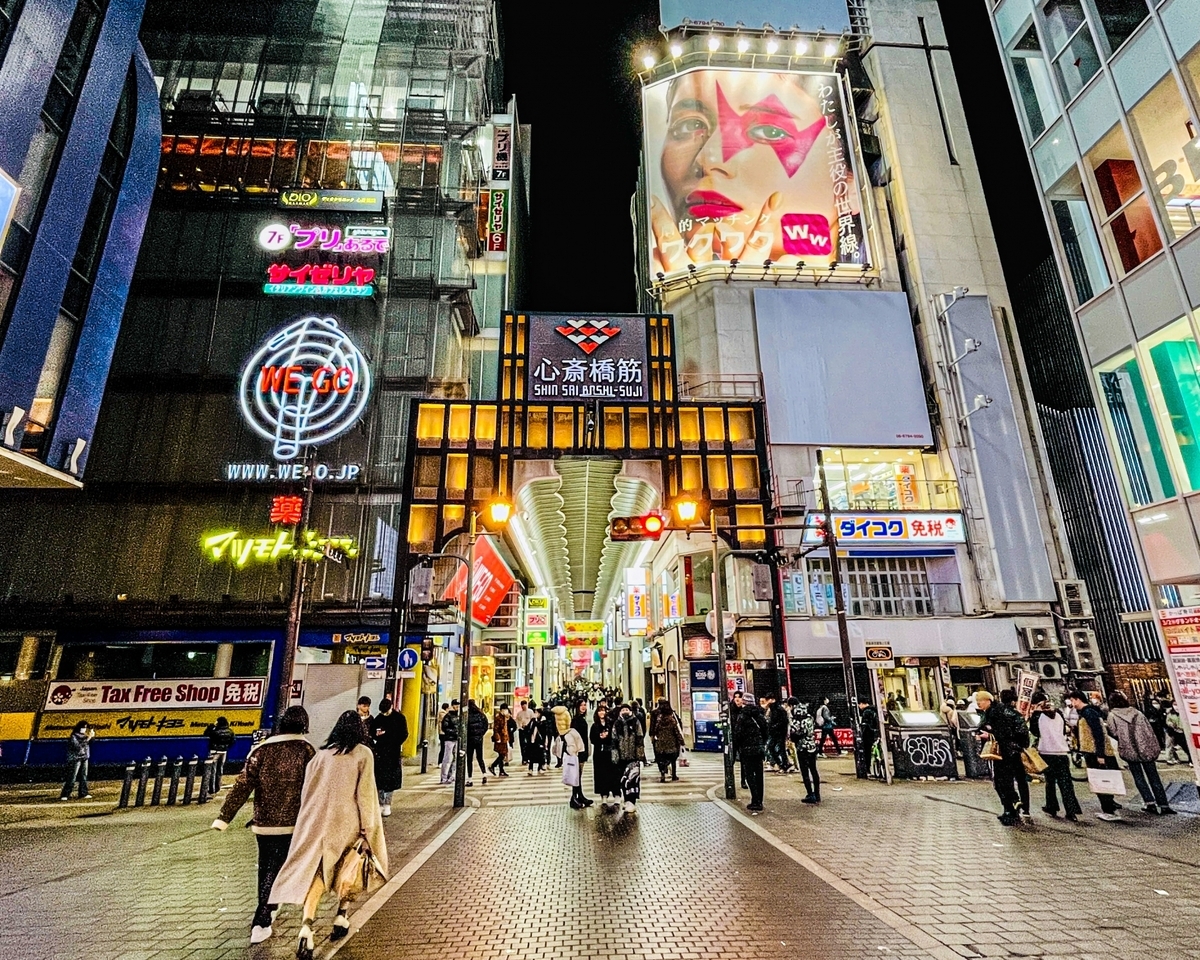 Vibrante escena de gente caminando por la calle principal de Shinsaibashi de noche