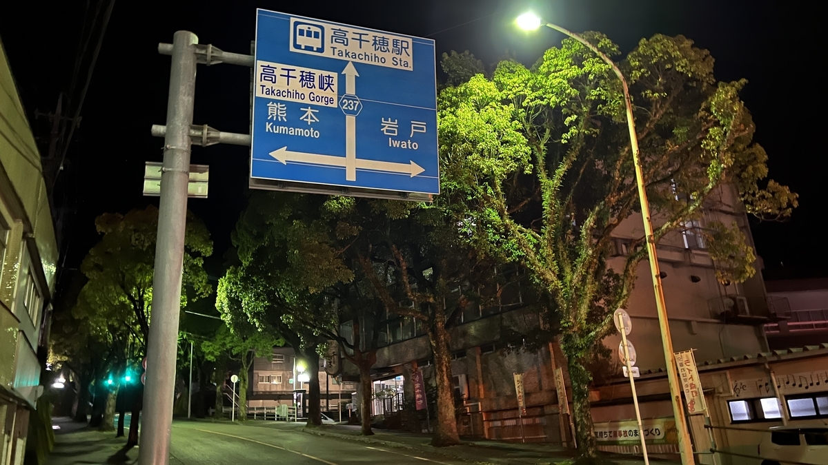 夜の高千穂町 神殿通りの交差点に立つ案内標識と街路樹