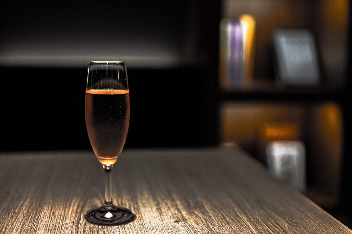 暗い店内でシャンパングラスに注がれた酒とカウンター席