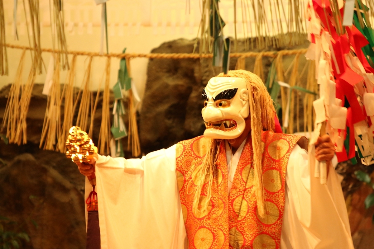 戴白色面具手持神器起舞的高千穗神樂舞者