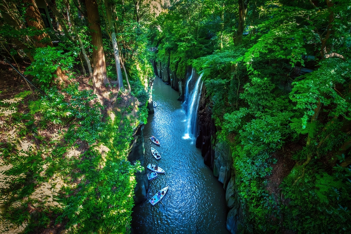 Columnar joints and Manai Falls at Takachiho Gorge with boats floating in the ravine