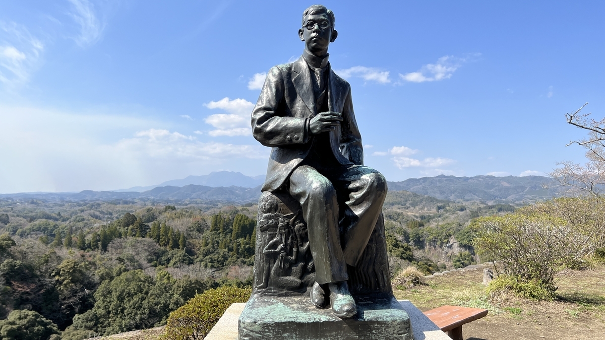 산맥을 배경으로 앉아 있는 다키 렌타로 동상