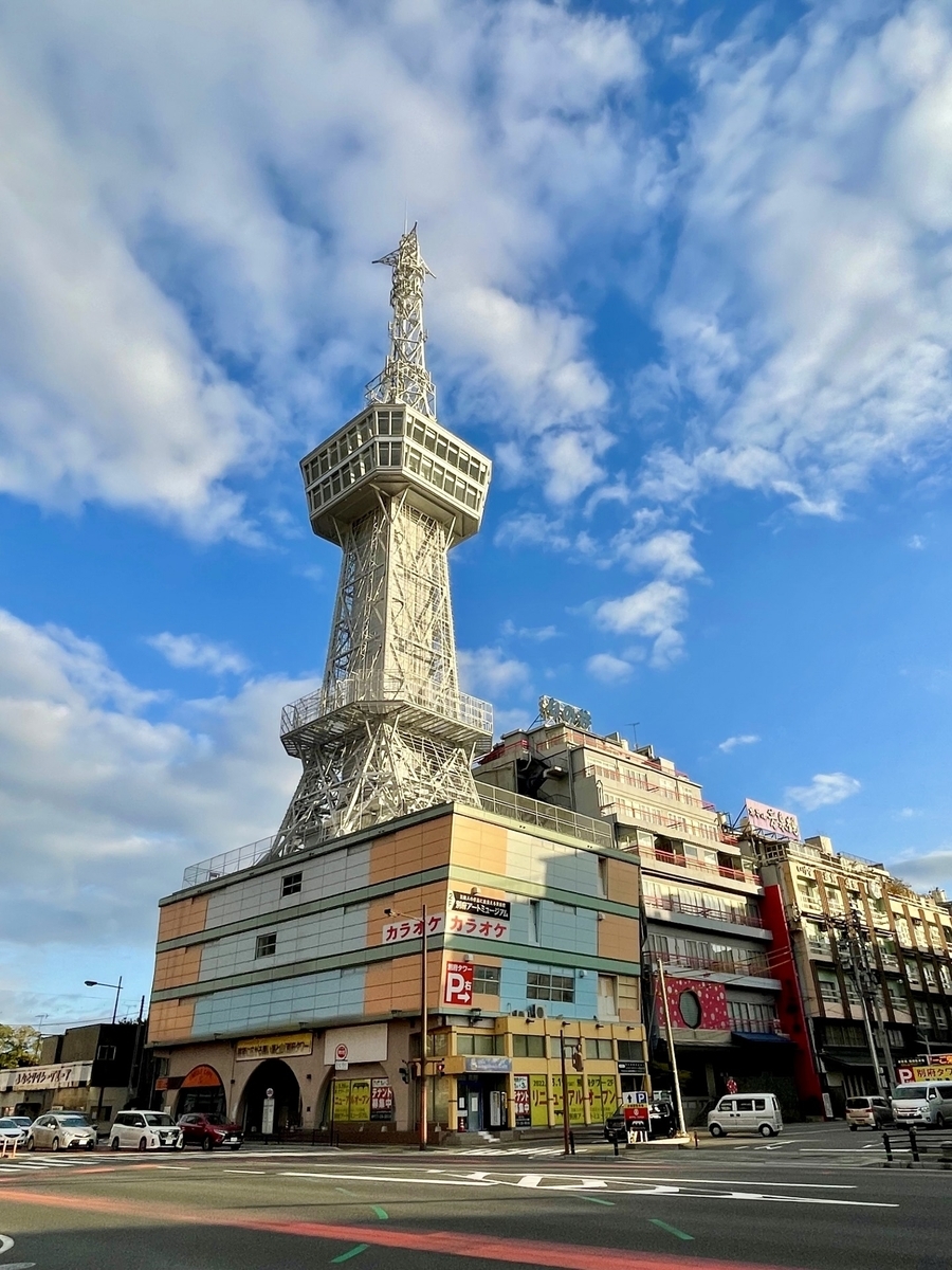 푸른 하늘 아래 서 있는 벳푸타워와 지상층 거리 풍경