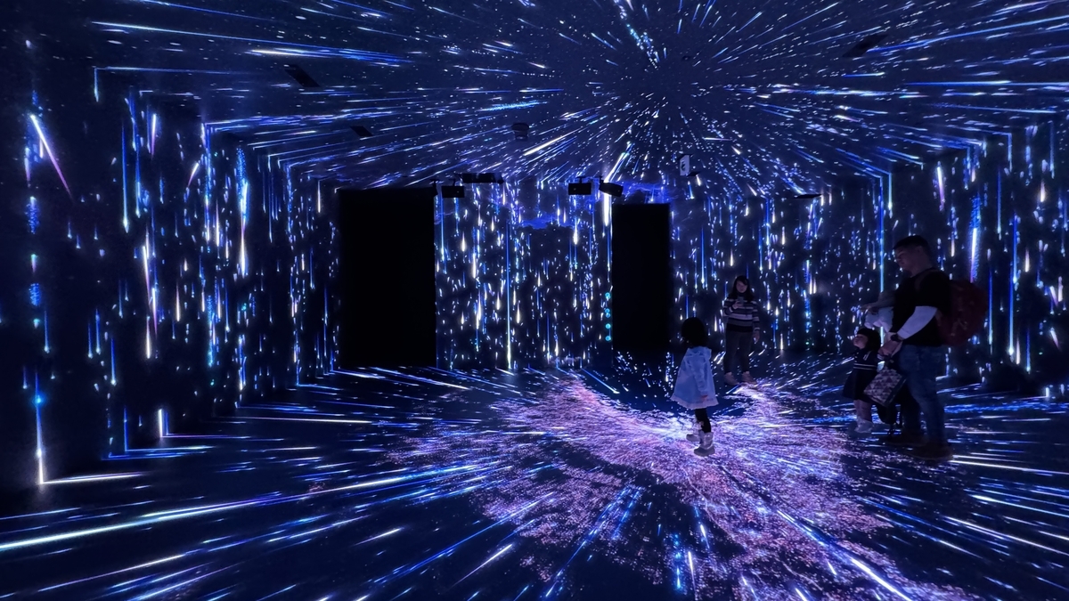 流星のような光が降り注ぐSKYエリアで遊ぶ家族連れ