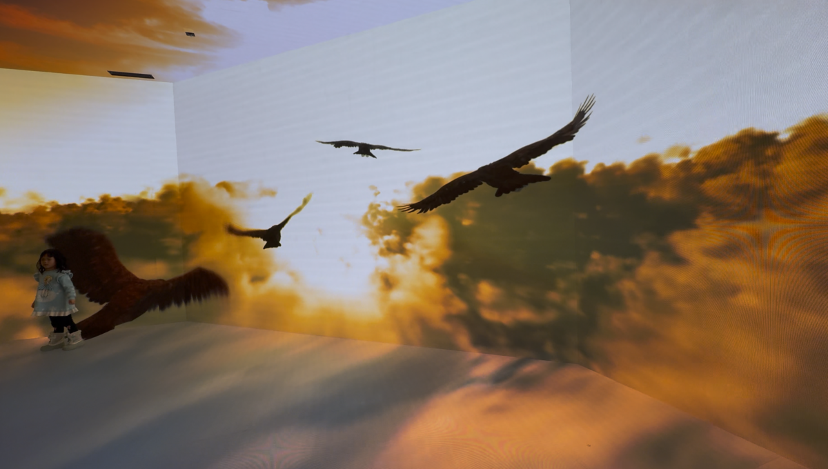 夕焼け空を飛ぶ鳥の映像が広がるSKYエリアと壁際に立つ子ども