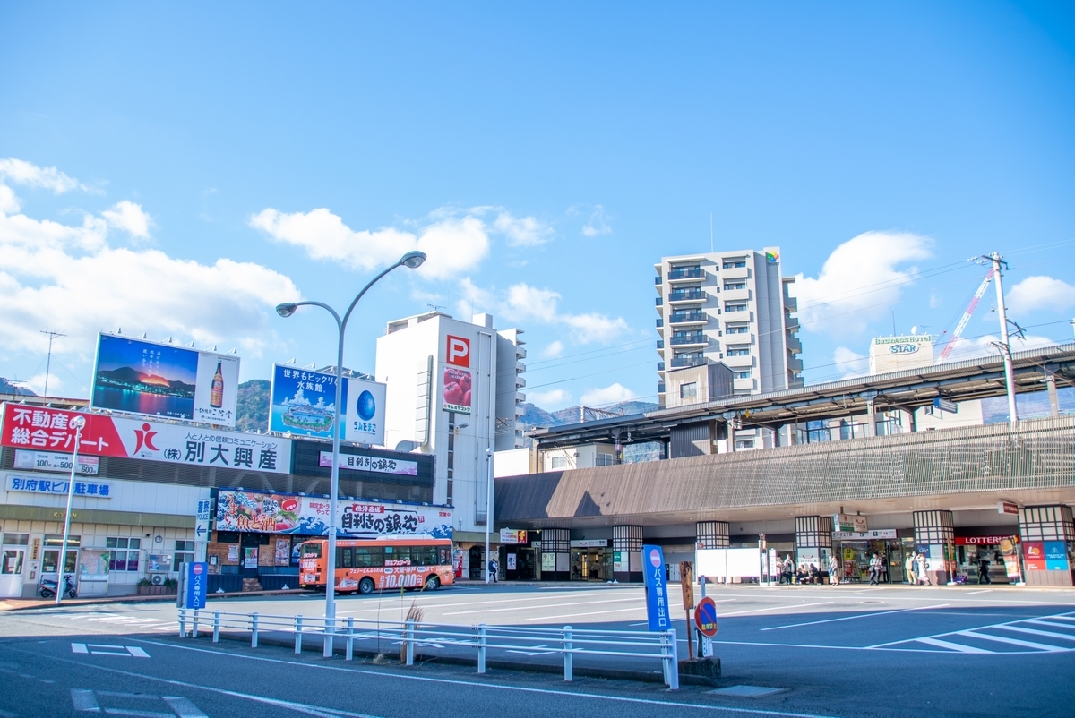 青空の下に広がるJR別府駅前のロータリーと駅舎の外観