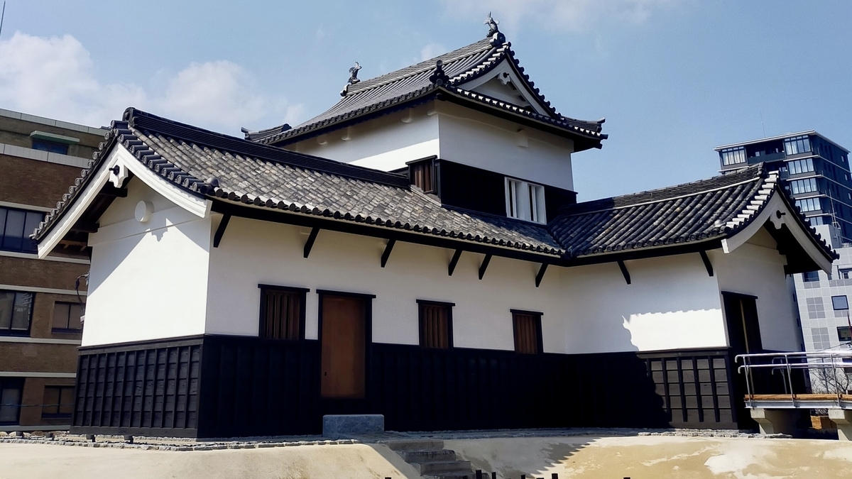 白牆黑瓦屋頂層疊的復原福岡城潮見櫓外觀與背後藍天