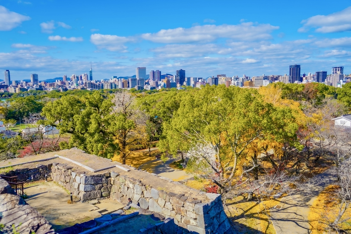 從福岡城天守台遺址眺望石垣與大濠公園綠色那邊的福岡市區