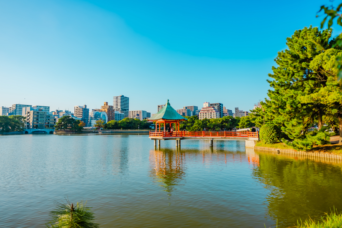 大濠公園池塘中漂浮的浮見堂與紅色棧橋倒映水面