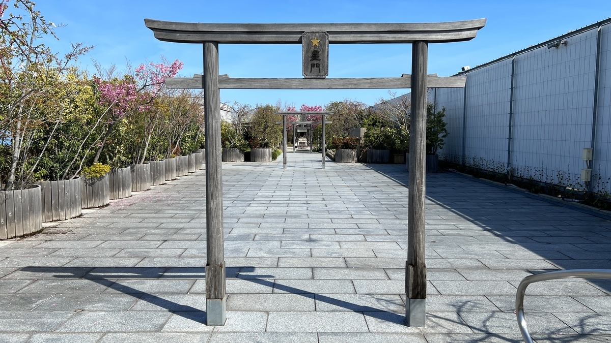 Santuario Ferroviario de Hakata con un torii de madera marcado como Puerta de Estrellas a lo largo de un camino de piedra, con un pequeno salon principal visible mas alla