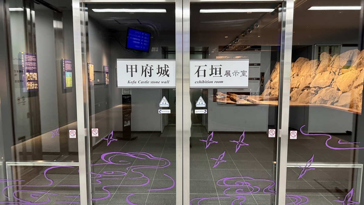 甲府城石垣展示室入口玻璃門和館名標牌