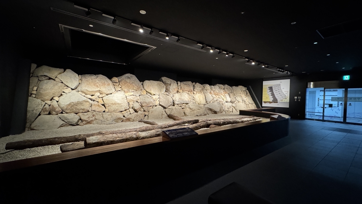 展示室內復原的野面積石垣和前方排列的胴木