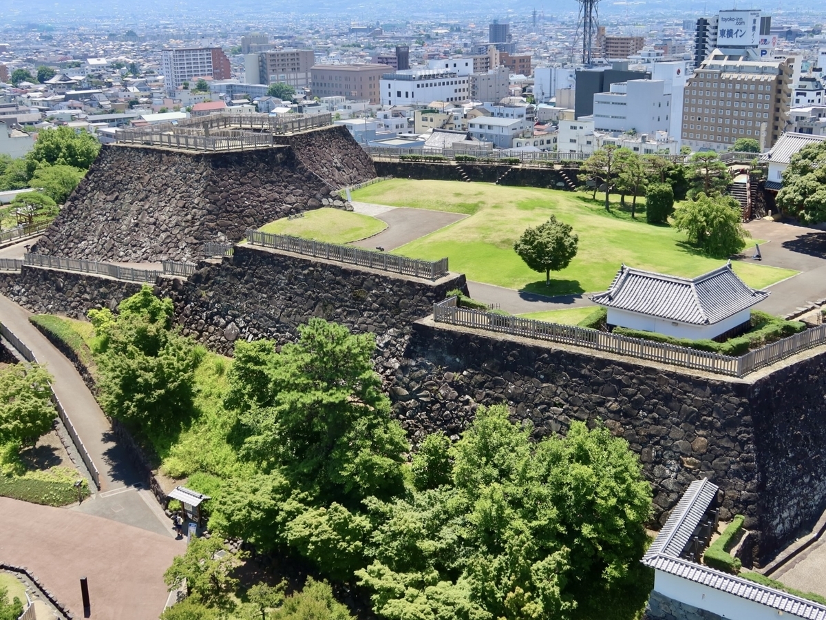 고후성의 높은 석벽과 잔디로 덮인 성곽을 조망한 풍경