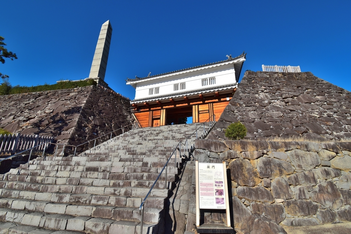 돌계단 정면에 서 있는 쿠로가네 문과 양쪽의 석벽