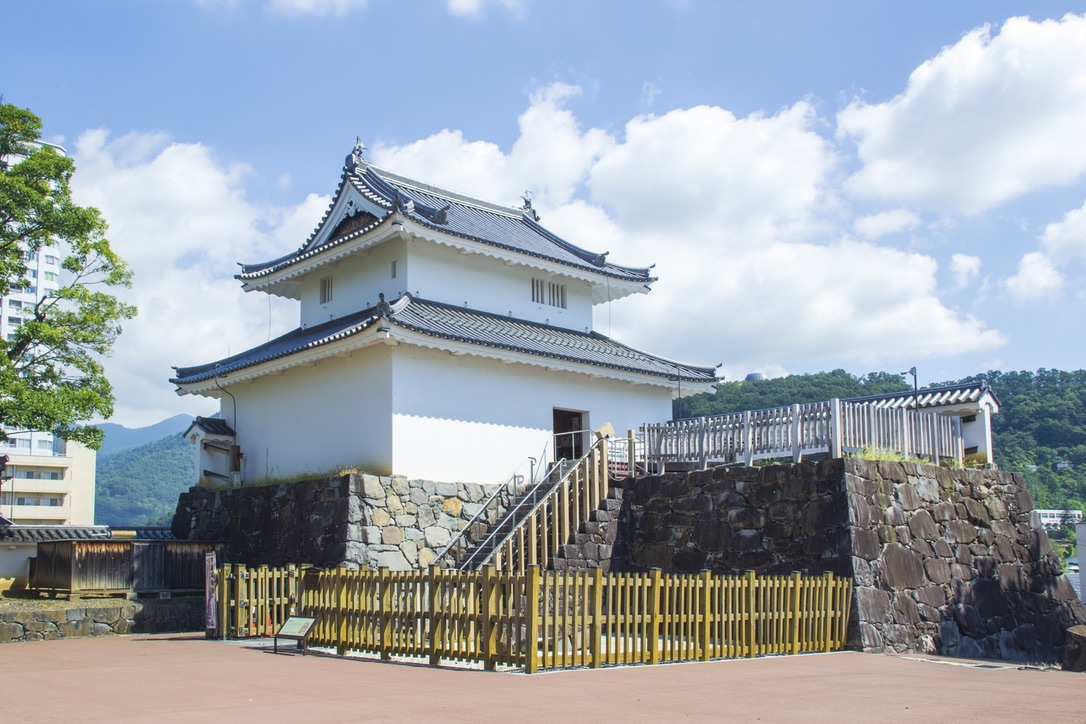 석벽 위에 세워진 흰 벽의 이나리 망루와 푸른 하늘