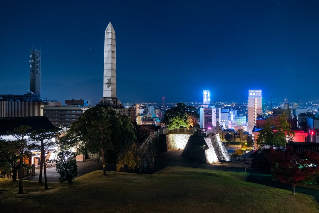 석비가 서 있는 혼마루 터와 조명 켜진 석벽의 야경