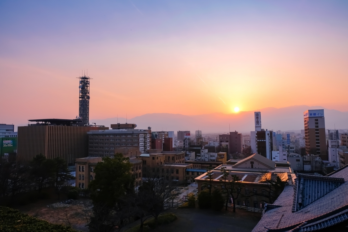 고후 시가지 건물 너머로 지는 석양과 산맥