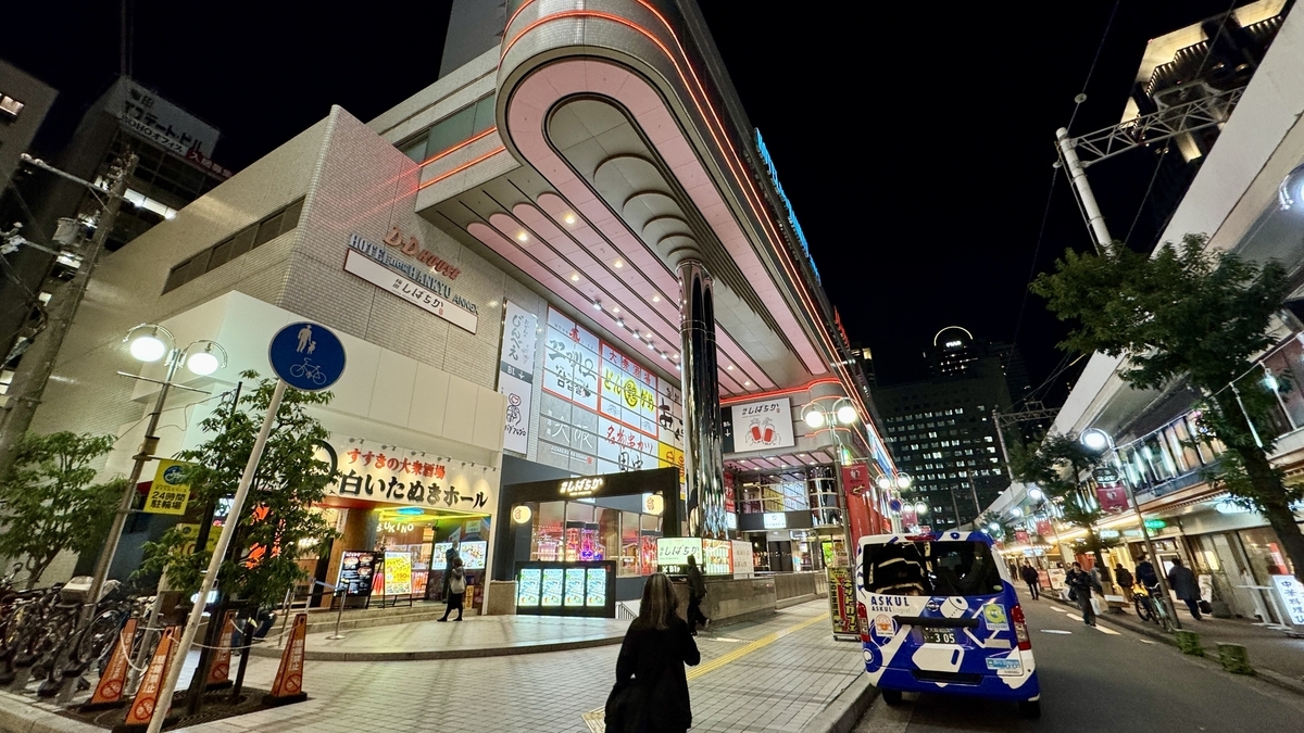 밤의 한큐 오사카우메다역 앞에 있는 D.D. HOUSE의 곡선형 외관과 네온 불빛