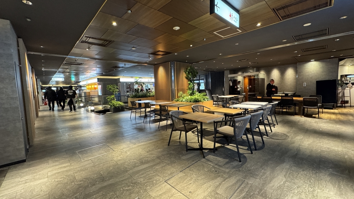 나무 천장과 식물로 둘러싸인 우메다 시바치카 공용 플로어와 테이블 좌석