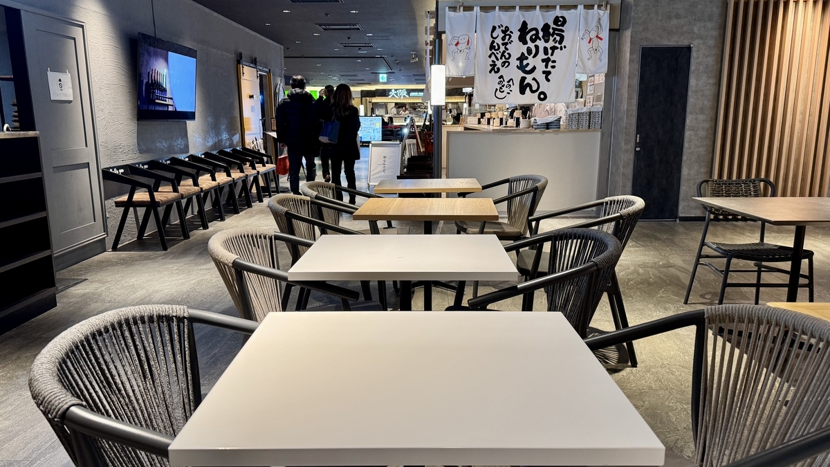 음식점 앞에 놓인 둥근 의자와 테이블 좌석이 있는 우메다 시바치카 휴식 공간