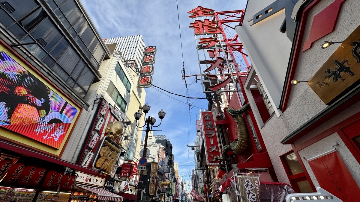 Vibrant Dotonbori street scene with giant signs for Kani Doraku crab restaurant and Kinryu Ramen