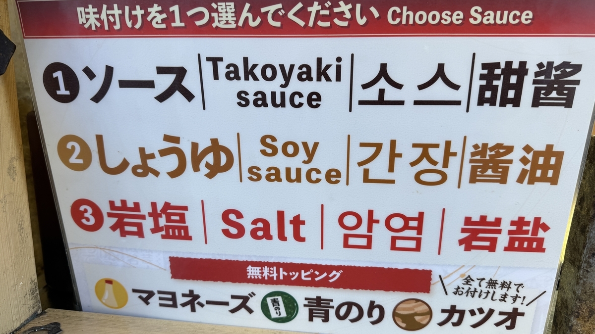 Menu board showing sauce, soy sauce, and rock salt options with free topping sign