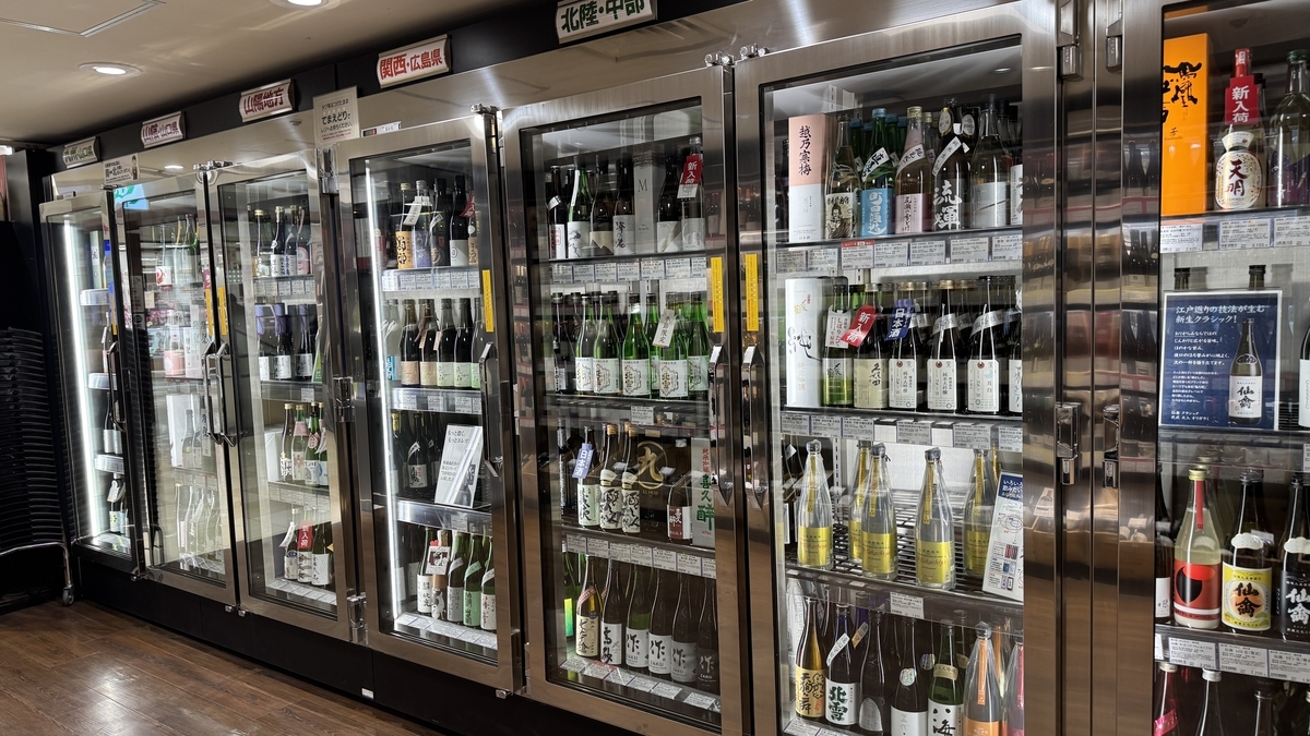 ขวดสาเกและฉลากที่จัดแสดงในตู้แช่เย็นของร้านขายเหล้า