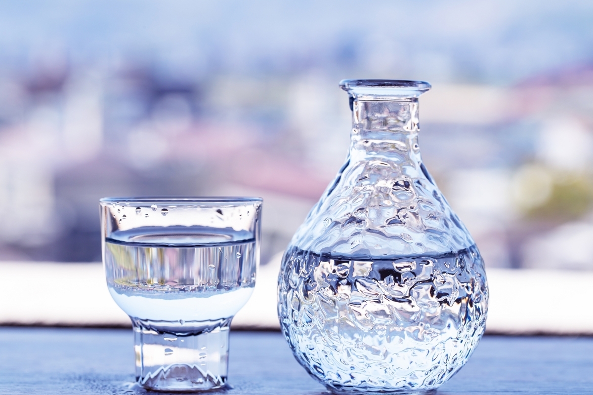 창가의 조용한 테이블 위에 놓인 투명한 도쿠리와 오초코에 담긴 사케