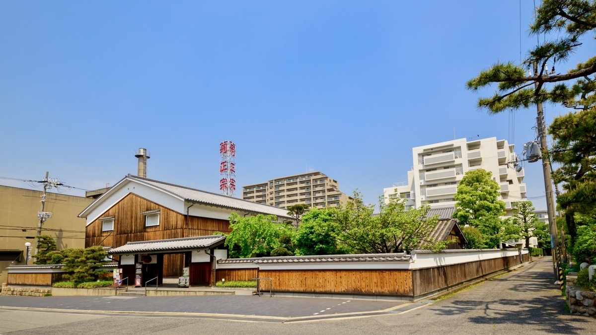 기쿠마사무네의 간판이 보이는 양조장 시설 외관과 나무 울타리로 둘러싸인 부지