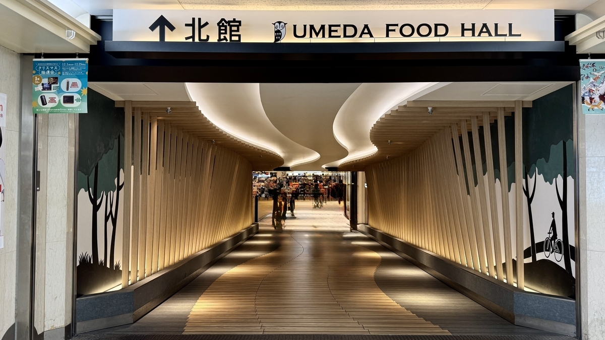 중앙 시계 조형물을 둘러싼 UMEDA FOOD HALL의 공용 좌석 구역과 주변 매장