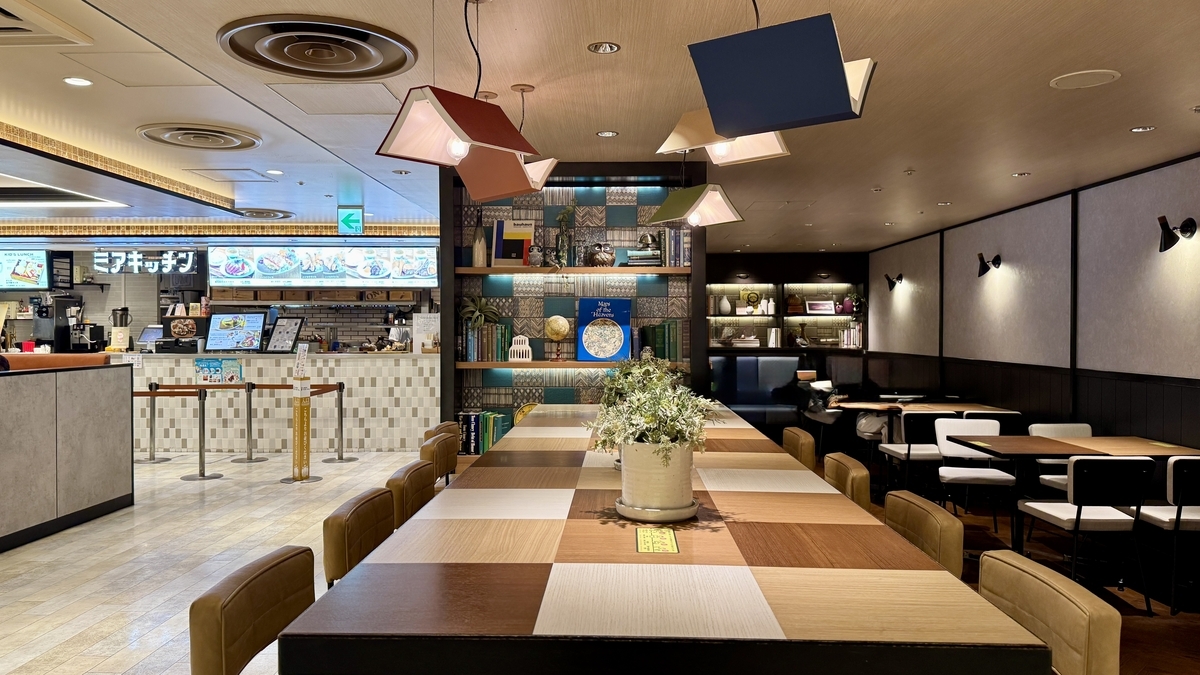 칸막이와 높은 의자가 있는 긴 카운터 테이블이 이어지는 푸드홀 통로 쪽 좌석