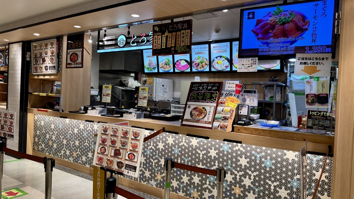 해산물덮밥 사진이 있는 메뉴 보드가 줄지어 있는 오사카 도지마 토로야 주문 카운터