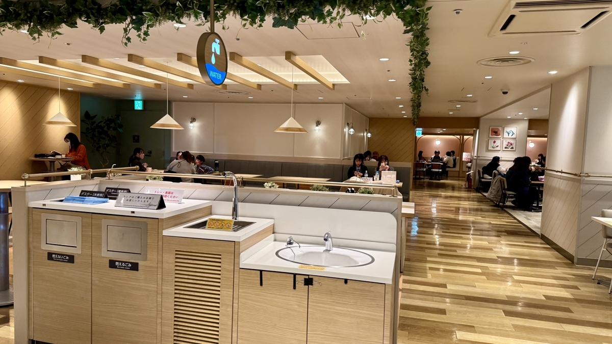 급수 안내판 아래에 쓰레기 분리수거함과 손 씻는 시설이 배치된 셀프서비스 코너