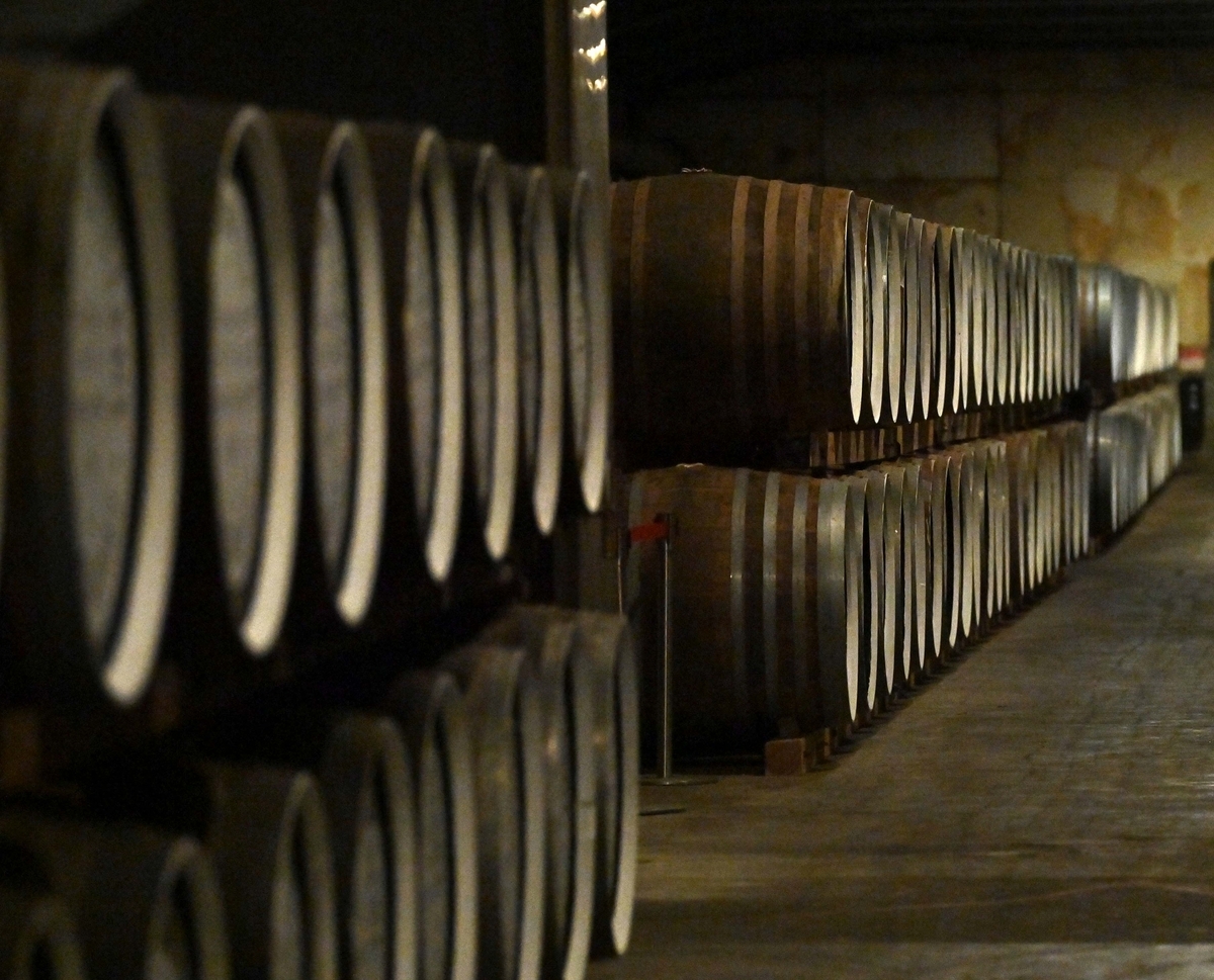 熟成庫の通路に沿って樽が二段で奥まで並ぶ様子