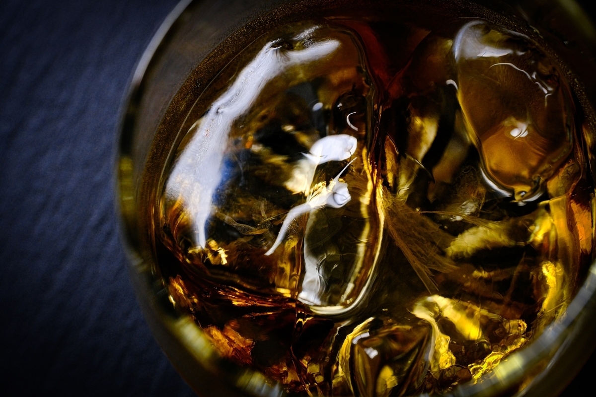 氷が入ったウイスキーグラスを真上から寄って写した抽象的な写真