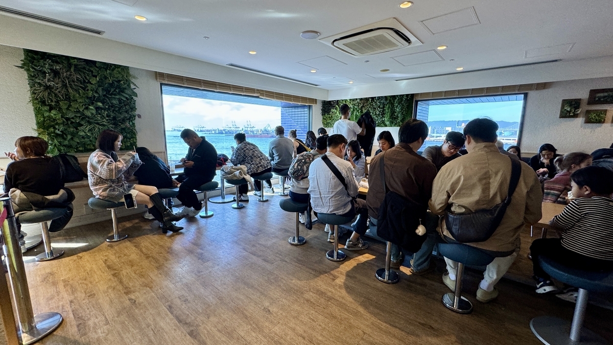 Cafe R.O.F店内,许多游客坐在临窗座位上眺望大阪湾