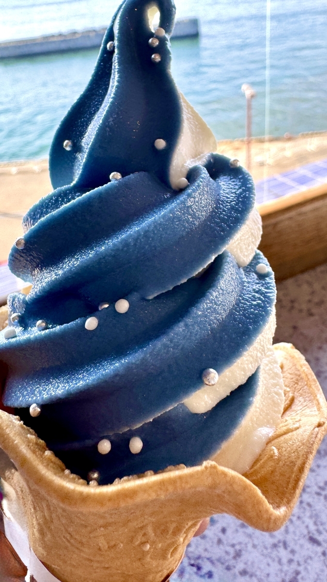 蓝白双色鲸鲨冰淇淋特写,上面点缀着糖珠,背景是大阪湾
