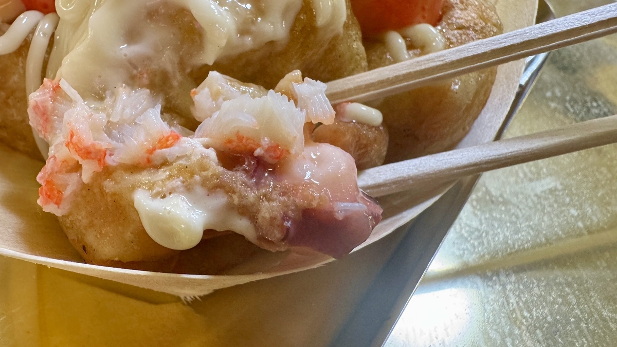 젓가락으로 가른 다코야키 속 게와 문어