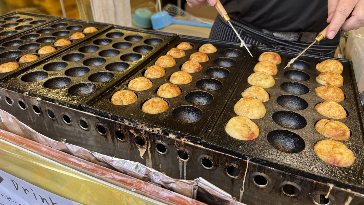 철판에서 다코야키를 뒤집고 있는 조리 모습