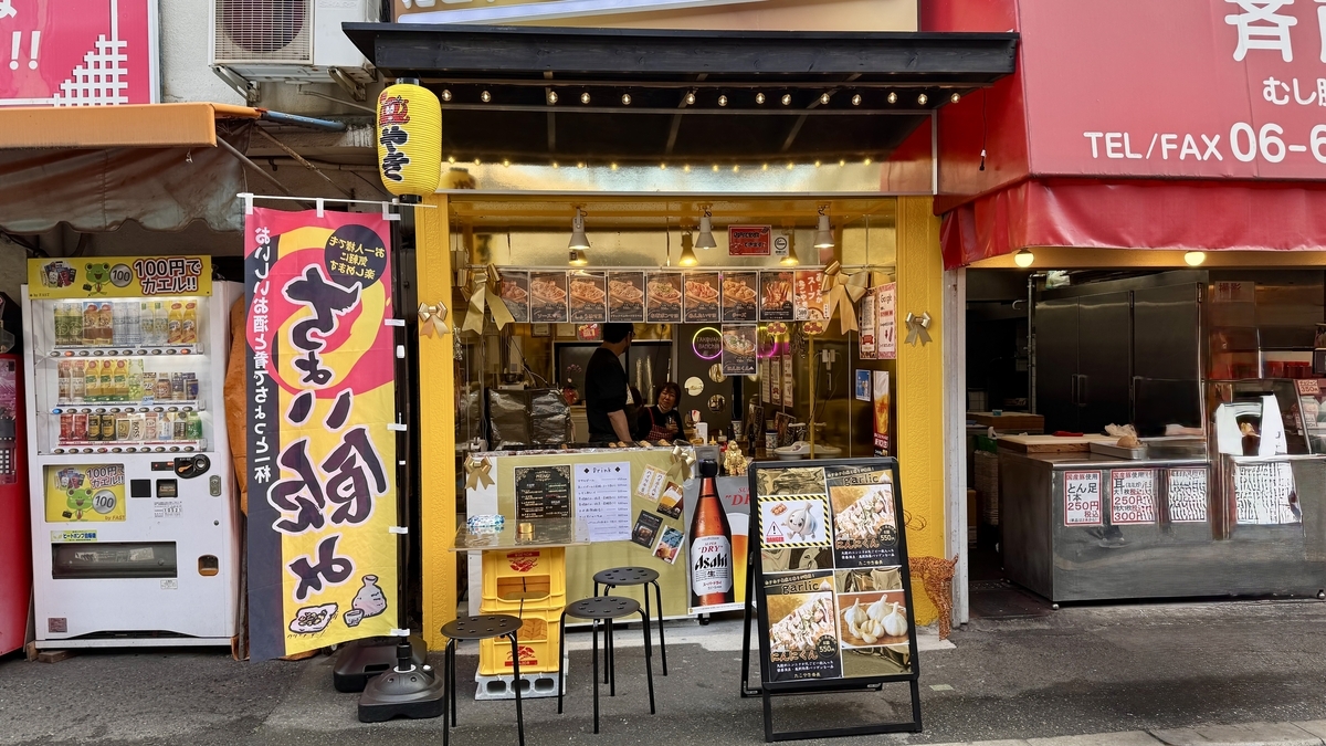 노란 외관과 깃발이 눈에 띄는 Takoyaki Bancho 가게 앞