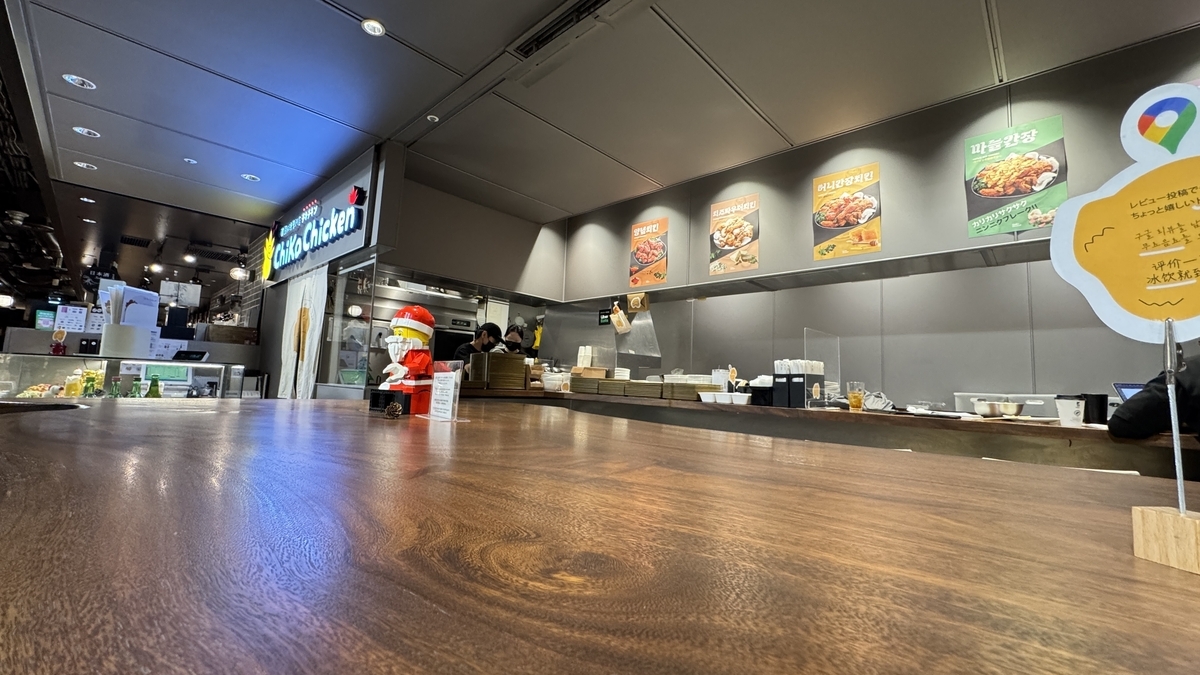 韓国語ポスターが並ぶチカチキンのカウンター席